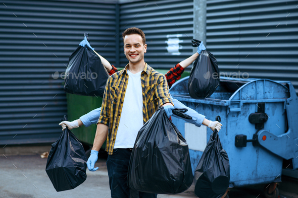 Funny volunteers shows plastic trash bags outdoors - Stock Photo - Images