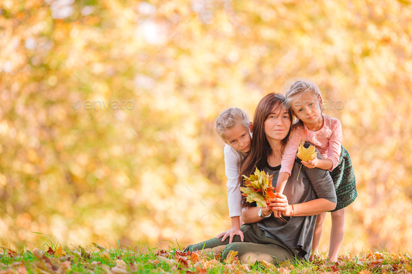 Little girl with mom outdoors in park at autumn day - Stock Photo - Images