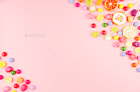 Flat lay view at sweet background of different type color and taste candies on pink. Space for text - Stock Photo - Images
