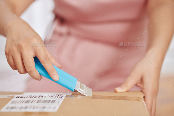 Woman opening cardboard box