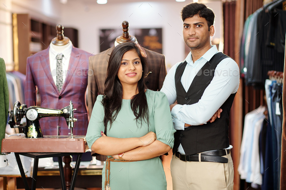 Confident team of young Indian tailors standing in their atelier