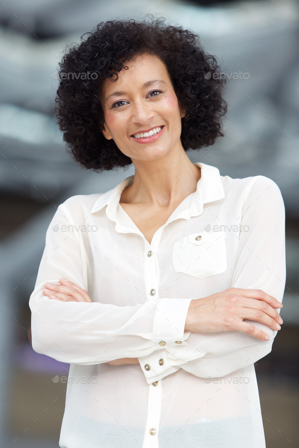 smiling middle age african american woman with arms crossed - Stock Photo - Images