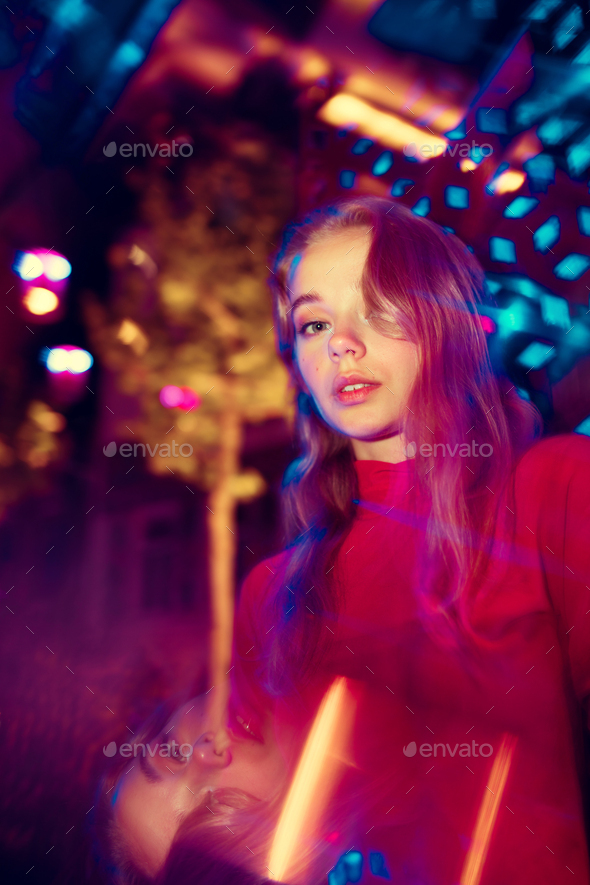 Cinematic portrait of handsome young woman in neon lighted room, stylish musician - Stock Photo - Images