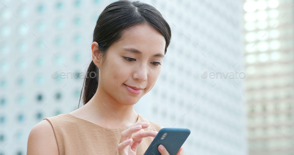 Woman use of mobile phone in the street - Stock Photo - Images