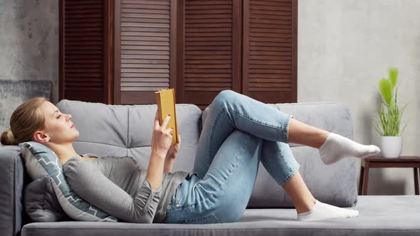 Young woman works with documents using a laptop at home. alt