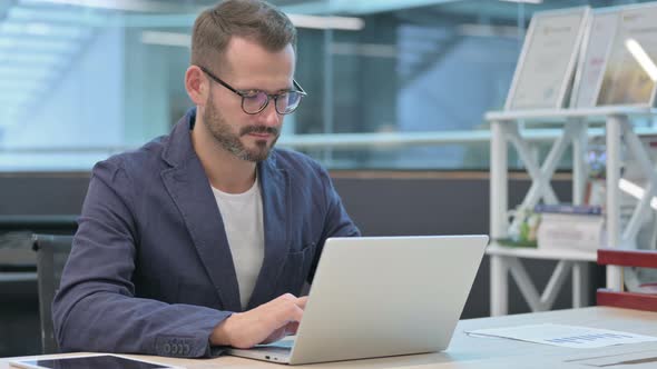 Middle Aged Businessman Working on Laptop in Office in Office alt