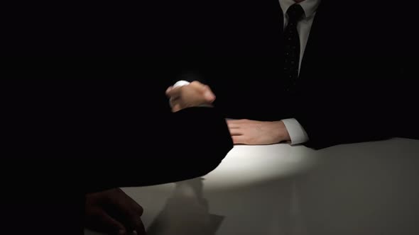 Anonymous business partners making handshake at the meeting in dark room