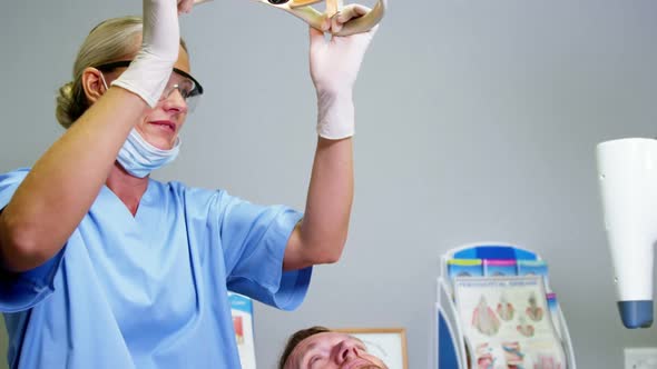 Female dentist assistant adjusting dental light alt