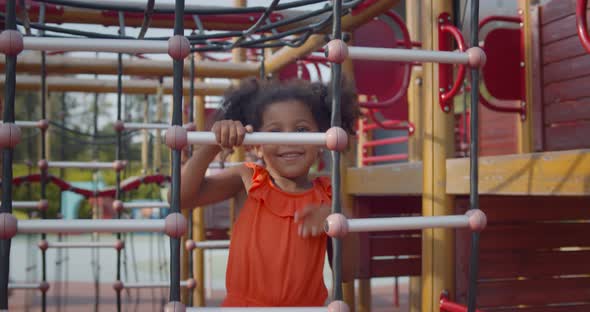 African Kid Having Fun with Climbing Net Outdoors alt