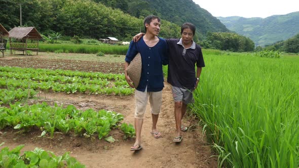Young Farmer Walking And Talking With His Father alt