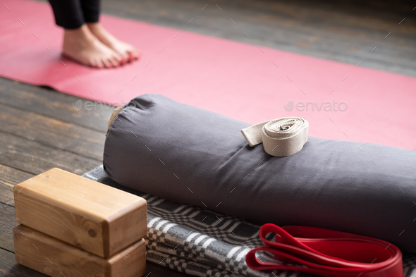 Caucasian females legs on yoga mat. Yoga props for Iyengar lesson.