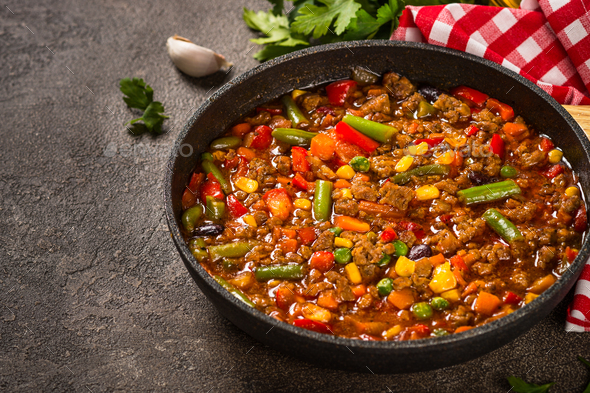 Chili con carne in skillet on dark stone table - Stock Photo - Images