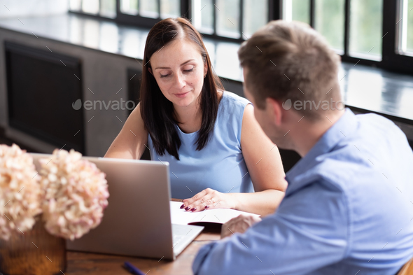 Businesswoman explaining something to her coworker in an office Stock ...