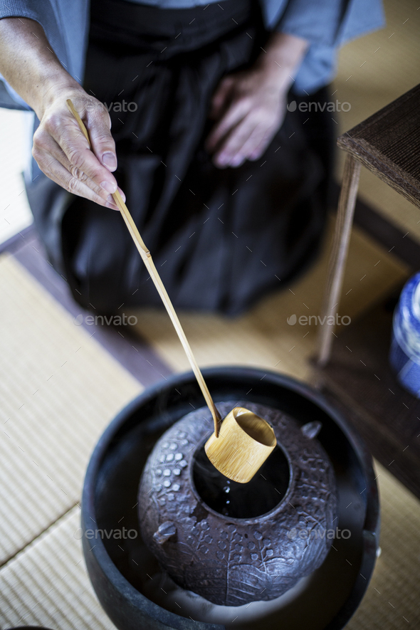 Traditional Japanese Tea Ceremony, man using a Hishaku, a bamboo ladle
