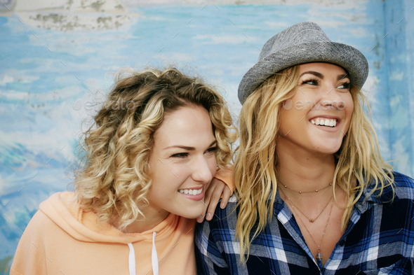Two smiling young women, one wearing grey Trilby hat - Stock Photo - Images