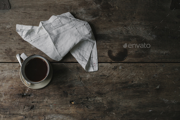 A cup of coffee and a napkin on a table.