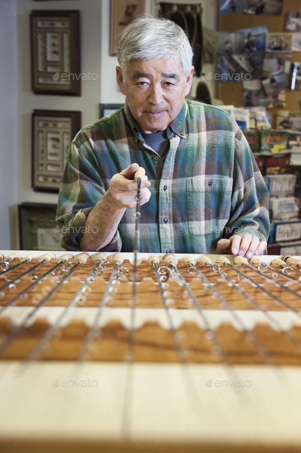 Asian American senior in a fly fishing shop.