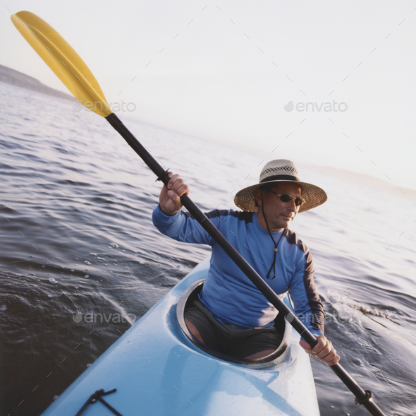 Man sea kayaking at dusk - Stock Photo - Images