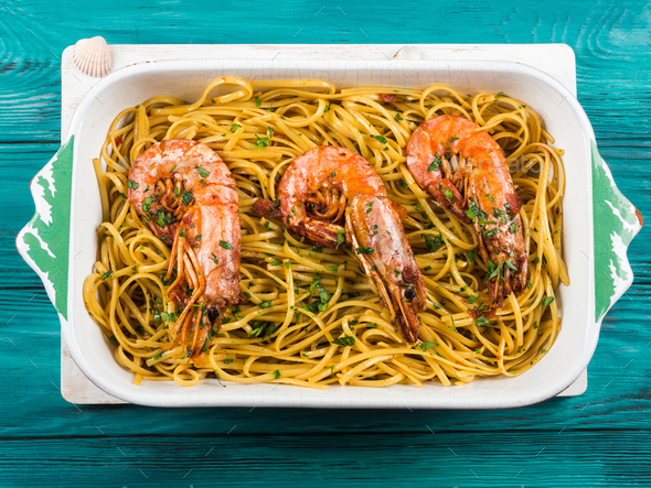 Linguine pasta with tiger prawn sauce in white dish - Stock Photo - Images