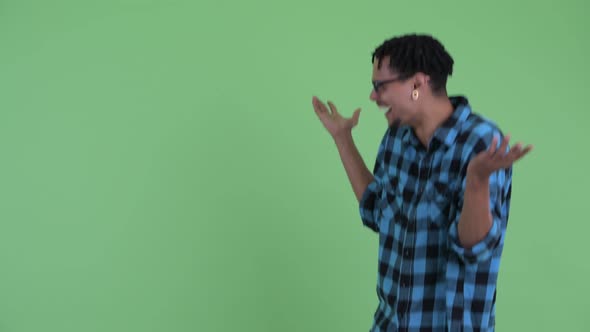 Happy Young African Hipster Man Touching Something and Looking Surprised alt
