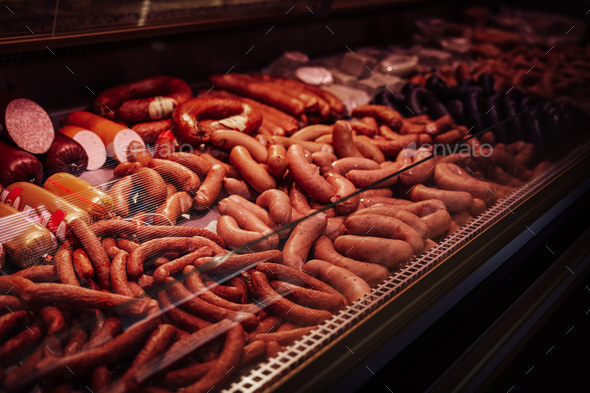 Variety choise of sausage products in meat shop. Ham and sausage in butcher shop. Smoked meat sale.