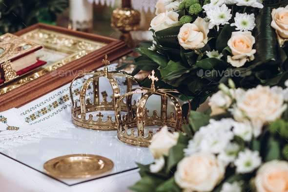 golden crowns and bible and wedding ring on altar in church at wedding matrimony