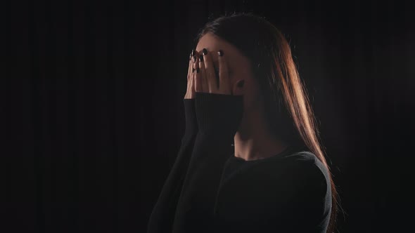 Girl In a Dark Room Scared And Covering Her Eyes