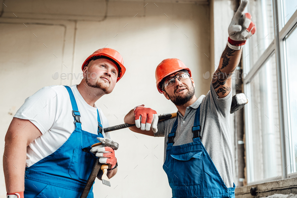 Two workers at a construction site, discussing forthcoming work