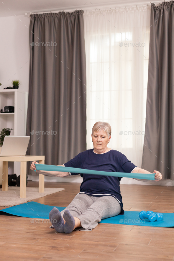 Strong old woman doing fitness for recovery at home. Old woman lifting training healthy lifestyle sport fitness workout at home with weights dumbbell activity.