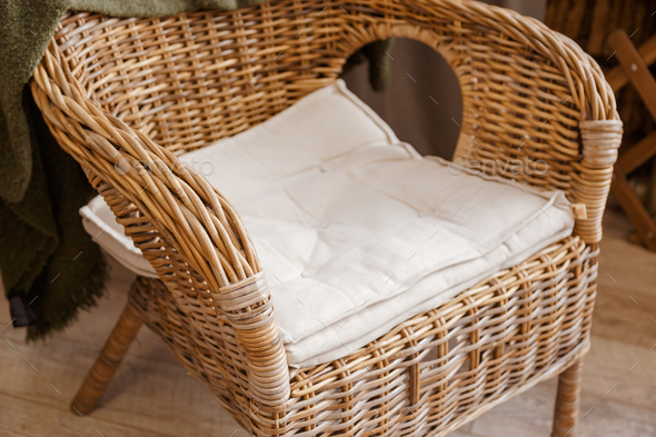 Rattan armchair with pillow close up view. Eco furniture.