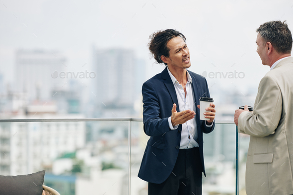 Angry emotional businessman trying to prove his point to colleague in conversation