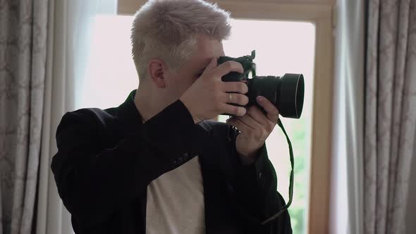 Man Photographer Takes Photographs on a Professional Camera alt