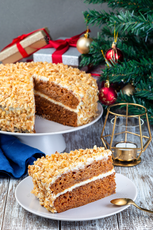 Piece of Carrot cake with cream cheese frosting and walnuts, Christmas decoration on background, vertical