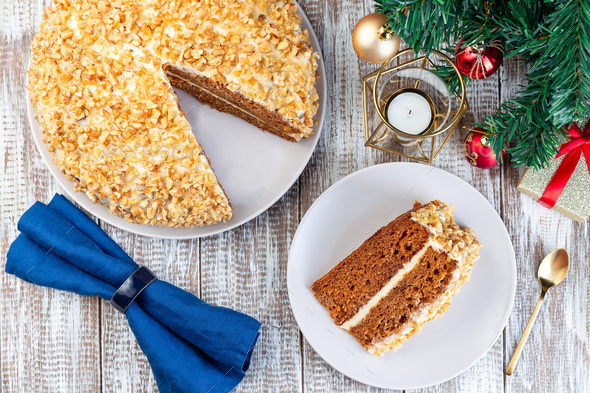Piece of Carrot cake with cream cheese frosting and walnuts, Christmas decoration on background, horizontal, top view