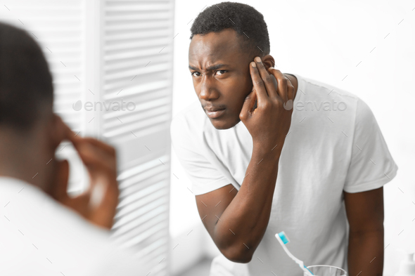 African American Man Having Hair Loss Problem Standing In Bathroom