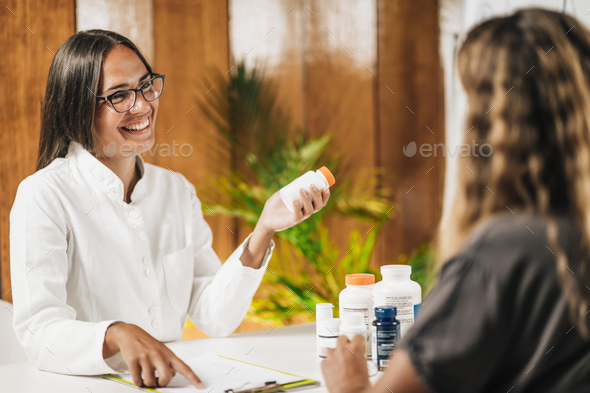 Functional medicine female practitioner recommending dietary supplement to a client