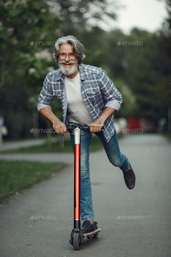 Vi ses privatliv Flipper Portrait of elderly man with kick scooter in a summer park Stock Photo by  prostooleh