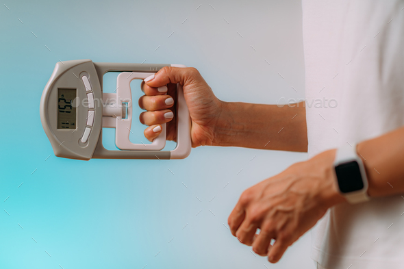 Woman with Digital Hand Grip Dynamometer, Measuring Strength