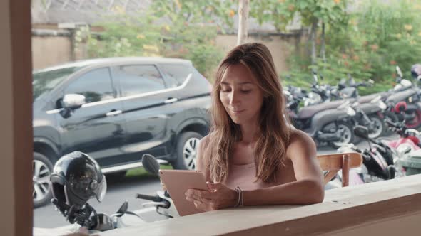 Woman Using Tablet in Street Cafe alt