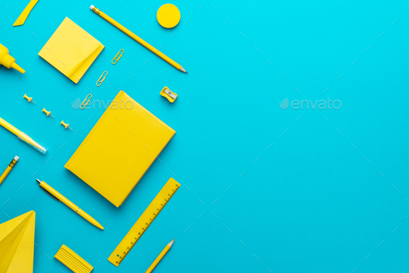 Top View Of Yellow Stationery Over Turquoise Blue Background With Copy  Space Stock Photo by garloon