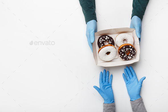 Pick up order of cakes during covid pandemic. Waiter in rubber gloves gives cardboard box with