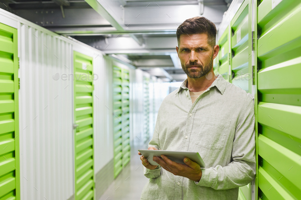 Bearded Man Using Tablet in Storage Unit