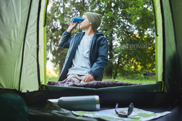 Teenage Boy Fishing by Lake Stock Photo by seventyfourimages