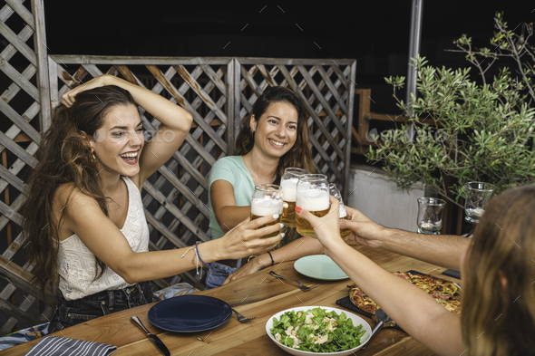 Beautiful Friends Laughing and Cheering With Beers and Eating Pizza - Stock Photo - Images