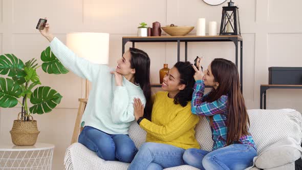 Happy multiracial girls taking selfie photo at home alt