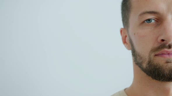 Slow Motion of Bearded Middle-aged Man Half Face on Grey-blue Background alt