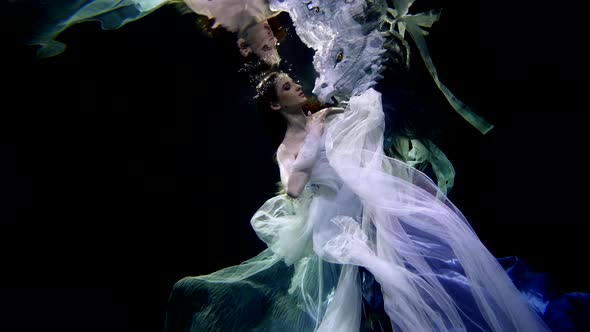 Underwater Princess in Depth of Ocean Female Figure in Silk Dress is Floating in Darkness Inside alt