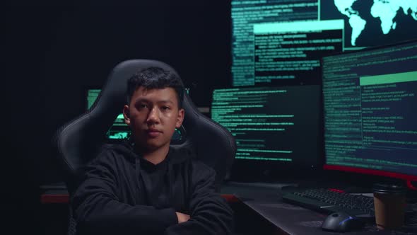 Asian Boy Hacker Hacking With Multiple Computer Screens And Pose In Dark Room alt
