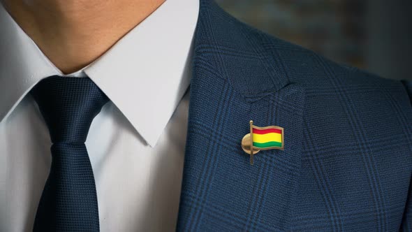 Businessman Walking Towards Camera With Country Flag Pin Bolivia alt