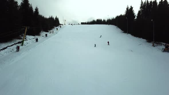 Aerial view of three skiers going down slope in Topolita Snow Summit. alt